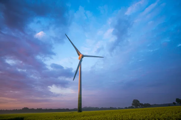 Windräder bei Sonnenaufgang und Nebel mit dunklen Wolken — Stockfoto