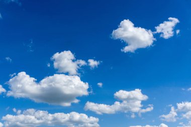 Beyaz bulutlar, güneş ışığı ile mavi gökyüzü