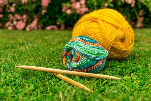 Vlna na pletení pro léto na zelený trávník na slunci s jehlami — Stock fotografie