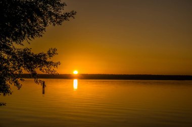 Gündoğumu ve küçük dalgalar küçük bir göl