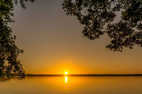 Küçük bir göl üzerinde gündoğumu, ağaçlar