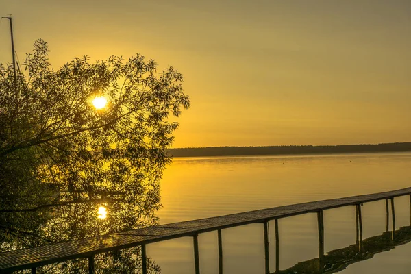 Salida del sol en un lago con amarres para barcos — Foto de Stock