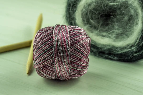 Wool for knitting with needles on a wooden table