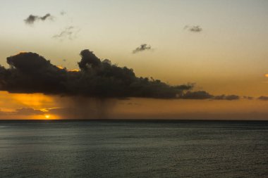 Karanlık yağmur bulutu ve yağmur, gündoğumu Atlantik Okyanusu üzerinden