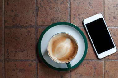 Kahve fincanı seramik tablo ve cep telefonu