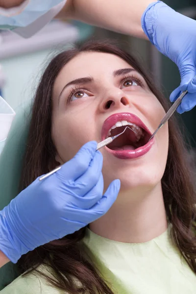 Dentista cura uma paciente do sexo feminino — Fotografia de Stock