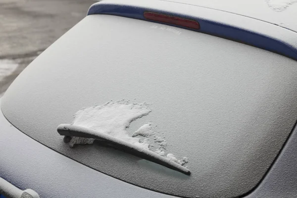 Carro estacionado coberto com a primeira neve no inverno — Fotografia de Stock