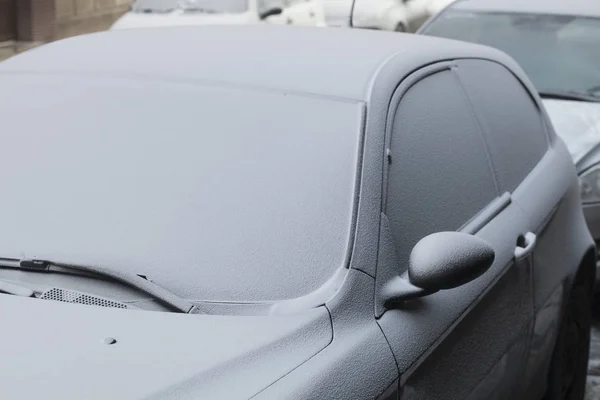 Zaparkowany samochód pokryte pierwszy śnieg w zimie — Zdjęcie stockowe