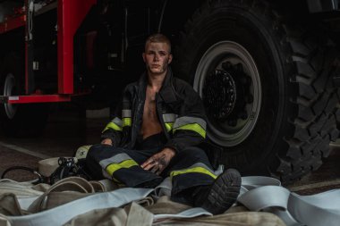 September 03, 2019, Ukraine Lviv city, young pretty and sexy firefighter sits by fire truck