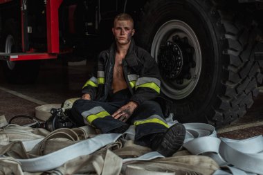 September 03, 2019, Ukraine Lviv city, young pretty and sexy firefighter sits by fire truck