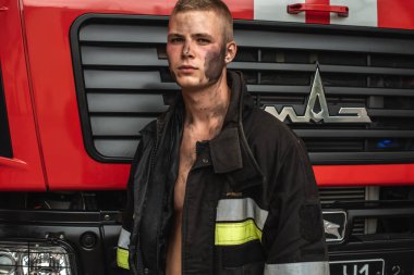 September 03, 2019, Ukraine Lviv city, young pretty and sexy firefighter sits by fire truck