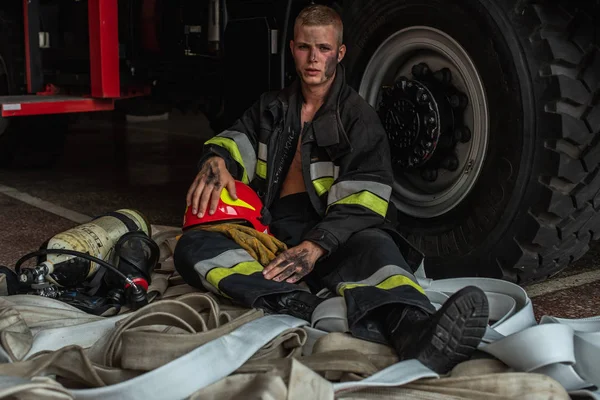 September 03, 2019, Ukraine Lviv city, young pretty and sexy firefighter sits by fire truck