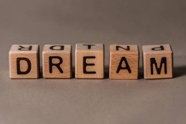 harf geçmişi. Kahverengi DREAM, Kraft arkaplanlı tahtadan küpler 