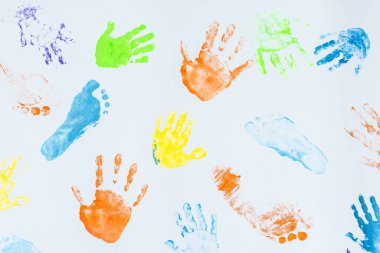 Beyaz arka planda çocuk el ve ayaklarının renkli baskıları 