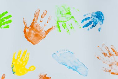 Beyaz arka planda çocuk el ve ayaklarının renkli baskıları