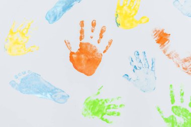 Beyaz arka planda çocuk el ve ayaklarının renkli baskıları 