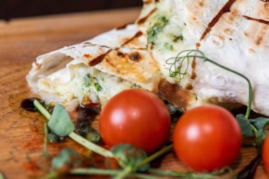 Tahta tepside etli, sebzeli ve domatesli pide.