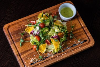 Tahtada domates, kırmızı biber, marul, avokado dilimlenmiş sebze. 