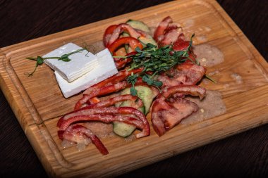 Domatesli sebze dilimleme, kırmızı biber, cevizli salatalık ve tahta üzerinde dilimlenmiş peynir. 