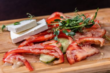 Domatesli sebze dilimleme, kırmızı biber, cevizli salatalık ve tahta üzerinde dilimlenmiş peynir. 