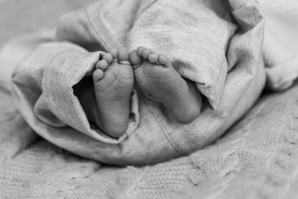 光の背景に生まれたばかりの赤ん坊の可愛くて小さな足 — ストック写真