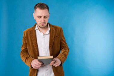 Genç iş adamı, Avrupalı iş adamı, iş adamı, takım elbiseli öğrenci mavi arka plan üzerine kitaplar tutuyor 