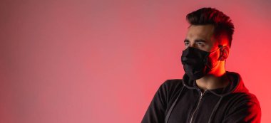 Siyah maskeli adam kırmızı arka plana bakıyor, tehlike, virüs, endişe, deneyim, koruma