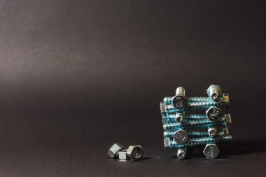 Bir satır arka planda metal cıvata ve somunlar. Krom vida cıvata ve somun izole. Çelik cıvata ve somun deseni. Somun ve cıvata seti. İş için araçlar. Siyah beyaz
