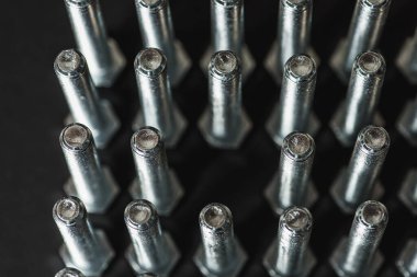 Bir satır arka planda metal cıvata ve somunlar. Krom vida cıvata ve somun izole. Çelik cıvata ve somun deseni. Somun ve cıvata seti. İş için araçlar. Siyah beyaz