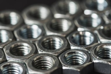 Karanlık arka planda izole edilmiş metal fındıklar. Krom vida fındık izole. Çelik ceviz izole. İş için araçlar.