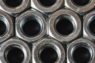 Karanlık arka planda izole edilmiş metal fındıklar. Krom vida fındık izole. Çelik ceviz izole. İş için araçlar.