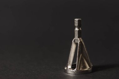 Koyu arkaplandaki faz çıkarımı için matkabın üzerindeki metal başlık. Kapat. 