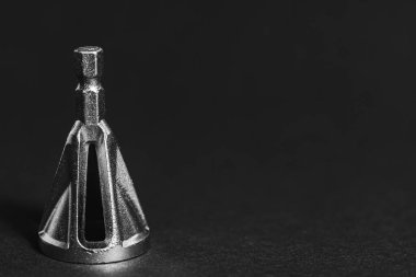 Koyu arkaplandaki faz çıkarımı için matkabın üzerindeki metal başlık. Kapat. 