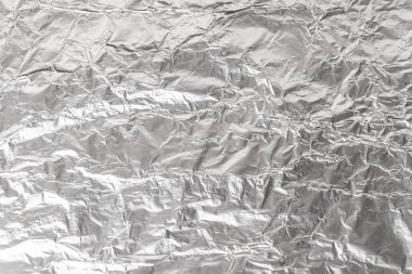 Buruşmuş alüminyum folyo kapağı. Gümüş alüminyum folyo doku arka planı. Metal kağıdın soyut deseni. Buruşmuş alüminyum mutfak folyosunun dokusu. Gümüş soyut arkaplan