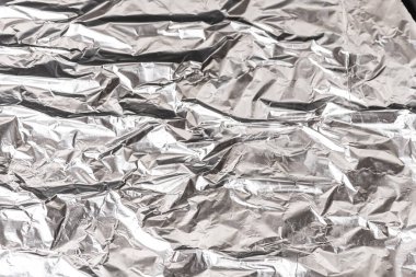 Buruşmuş alüminyum folyo kapağı. Gümüş alüminyum folyo doku arka planı. Metal kağıdın soyut deseni. Buruşmuş alüminyum mutfak folyosunun dokusu. Gümüş soyut arkaplan