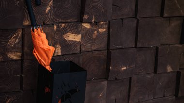 Ahşap ahşap ev duvarı ve turuncu şemsiye ayakta 