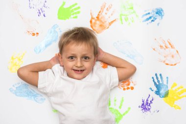 Küçük sarışın çocuk açık arkaplanda yüz ifadeleri gösteriyor. 