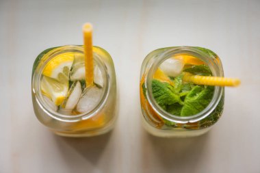 Limonlu, turuncu buzlu, hafif arka planda, yüksek anahtarlı alkolsüz yaz içeceği. 