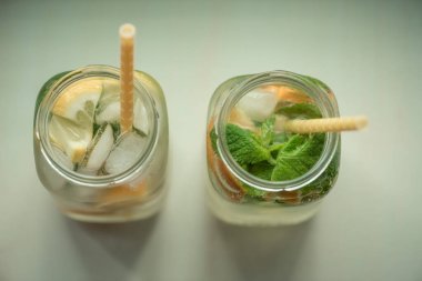 Limonlu, turuncu buzlu, hafif arka planda, yüksek anahtarlı alkolsüz yaz içeceği. 