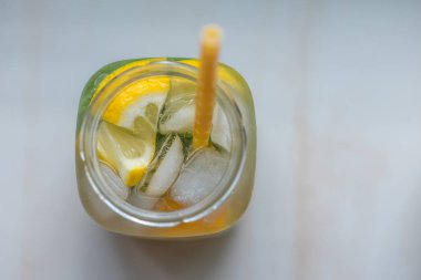 Limonlu, turuncu buzlu, hafif arka planda, yüksek anahtarlı alkolsüz yaz içeceği. 