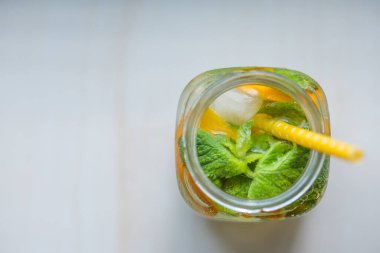 Limonlu, turuncu buzlu, hafif arka planda, yüksek anahtarlı alkolsüz yaz içeceği. 