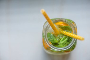 Limonlu, turuncu buzlu, hafif arka planda, yüksek anahtarlı alkolsüz yaz içeceği. 