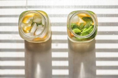 Limonlu, turuncu buzlu, hafif arka planda, yüksek anahtarlı alkolsüz yaz içeceği. 