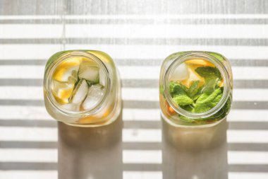 Limonlu, turuncu buzlu, hafif arka planda, yüksek anahtarlı alkolsüz yaz içeceği. 