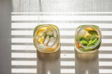 Limonlu, turuncu buzlu, hafif arka planda, yüksek anahtarlı alkolsüz yaz içeceği. 