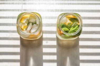 Limonlu, turuncu buzlu, hafif arka planda, yüksek anahtarlı alkolsüz yaz içeceği. 