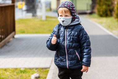 Şapkalı ve mavi tavuklu küçük bir çocuğun portresi, yüzünde bandajla, iki boyanmış bıyıklı fok sokaklarda farklı el hareketleri, salgın hastalık ve virüs gösteriyor.