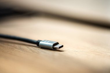 Akıllı telefon şarj kablosuna bağlan ve onu tahta bir yüzeye yerleştir.