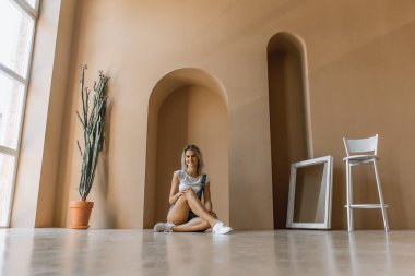 Genç, güzel, sarışın, güzel ve baştan çıkarıcı bir kız kot şortlu, mavi şortlu, gülümseyen duygular.