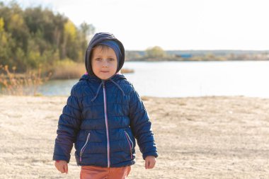 Mavi ceketli yakışıklı bir Avrupalı çocuk doğada duruyor. Sevimli bir bebeğin portresi. Adam..